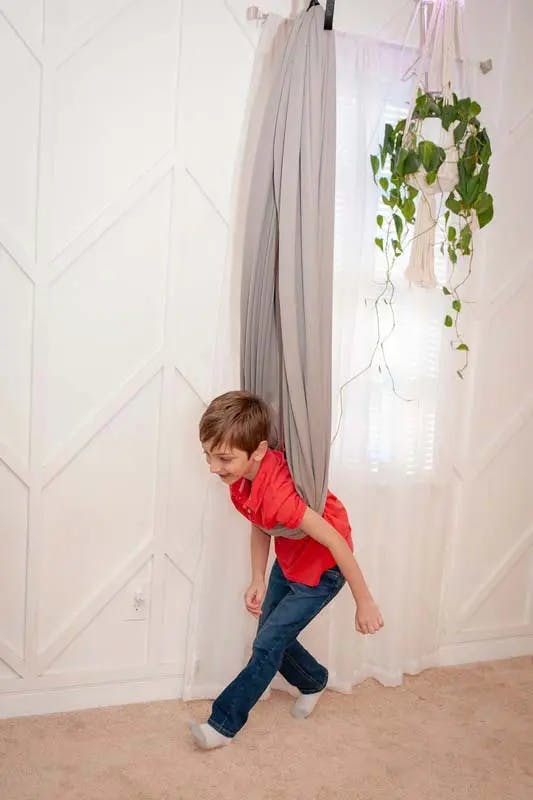 A child running in a Pebble sensory swing by 21st Sensory